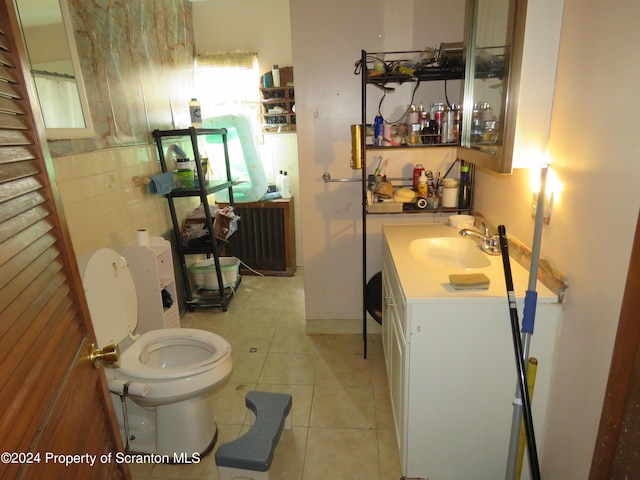 bathroom featuring tile patterned floors, vanity, tile walls, and toilet