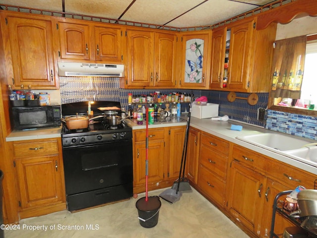 kitchen featuring backsplash, sink, and black appliances