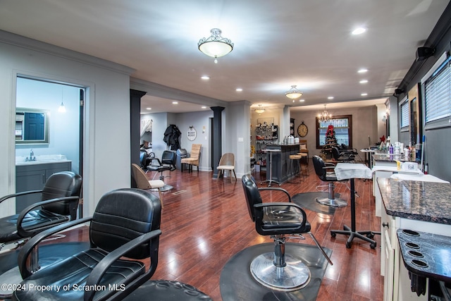 office space featuring sink, an inviting chandelier, dark wood-type flooring, and crown molding