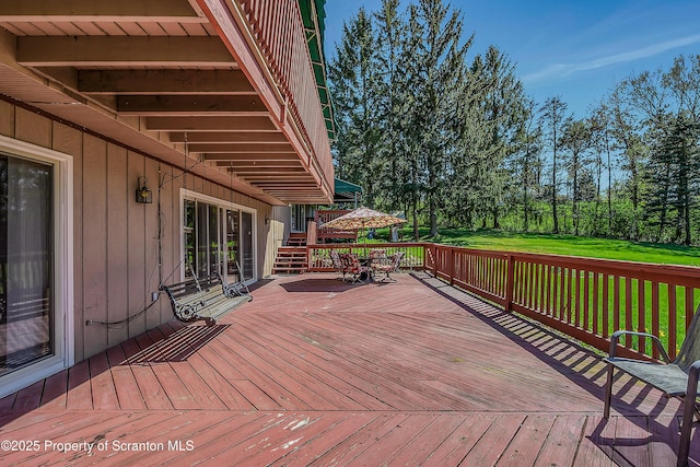 wooden deck featuring a lawn