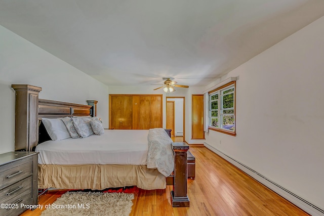 bedroom with a ceiling fan, baseboard heating, and hardwood / wood-style floors