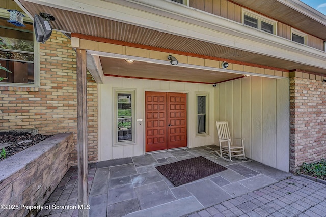 property entrance featuring brick siding and board and batten siding