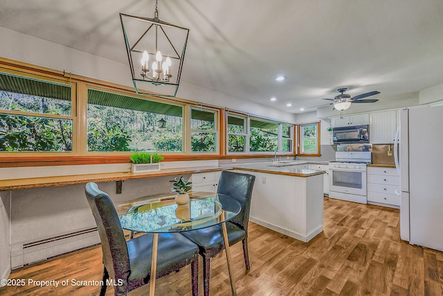 kitchen with a sink, white cabinets, light wood-style floors, recessed lighting, and white appliances