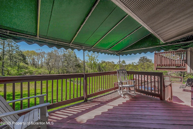 wooden deck featuring a lawn