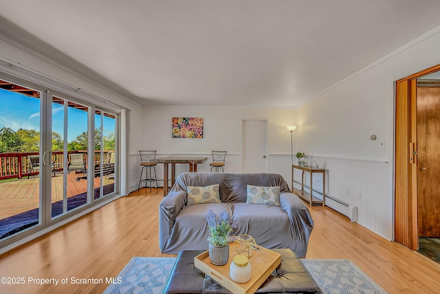 living area with light wood finished floors and a baseboard heating unit