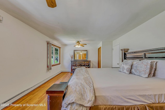 bedroom featuring ceiling fan, baseboard heating, and light wood finished floors