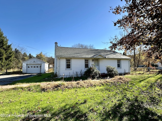 ranch-style home with a garage, an outbuilding, and a front lawn