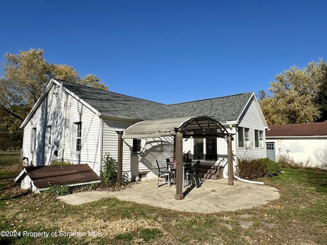 back of house featuring a pergola, a patio area, and a yard