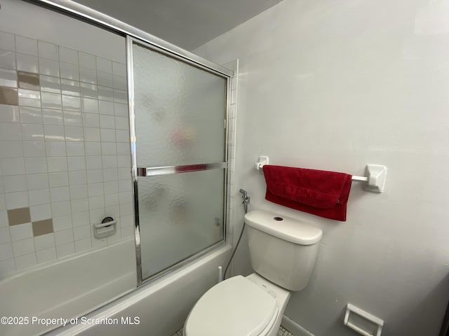 bathroom with toilet and bath / shower combo with glass door