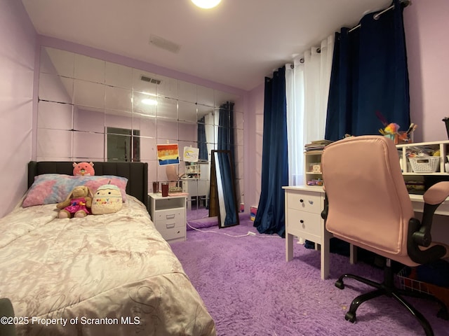 bedroom featuring visible vents, light colored carpet, and tile walls