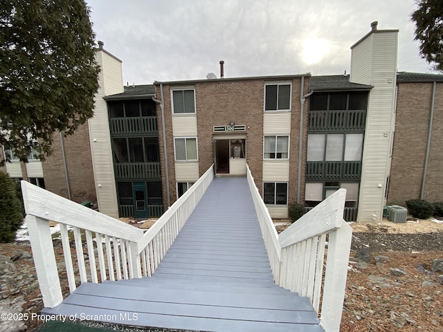 exterior space featuring central AC unit and brick siding