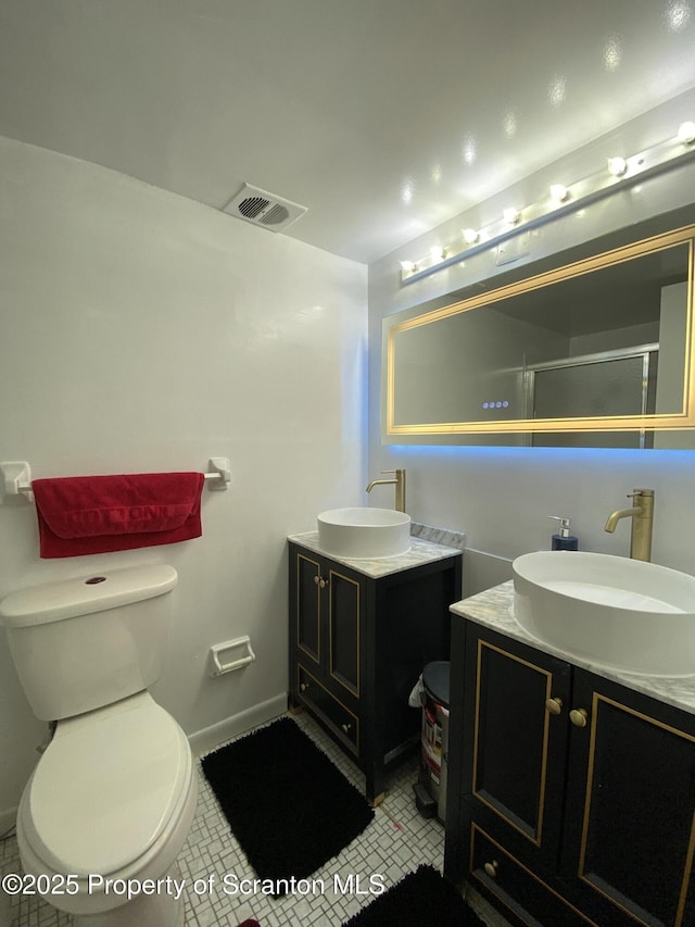 full bath featuring tile patterned flooring, two vanities, a sink, and visible vents