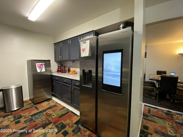 kitchen with tasteful backsplash, stainless steel fridge with ice dispenser, tile patterned floors, freestanding refrigerator, and light countertops