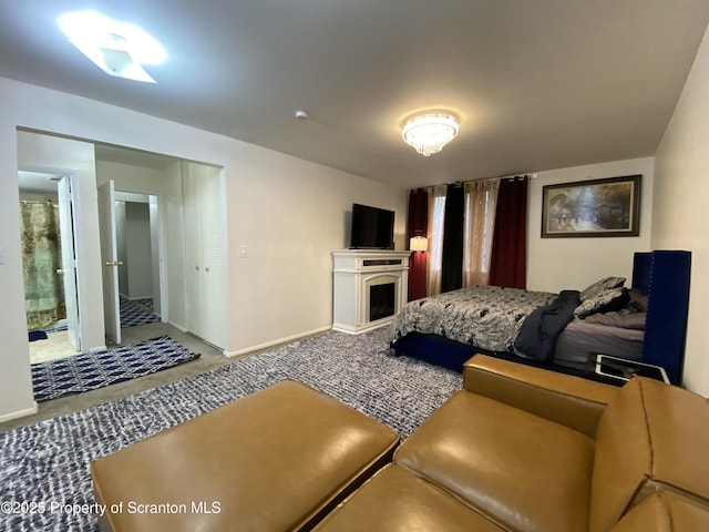 carpeted bedroom featuring baseboards and ensuite bathroom