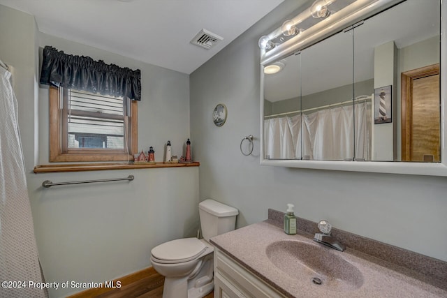 bathroom with hardwood / wood-style flooring, vanity, and toilet