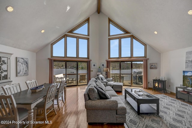 living room featuring beamed ceiling, high vaulted ceiling, wood-type flooring, and plenty of natural light