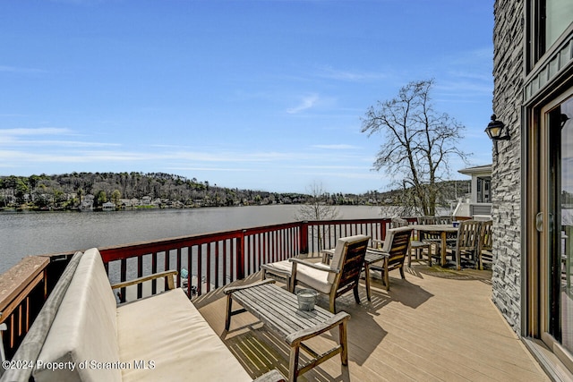 wooden terrace featuring outdoor lounge area and a water view