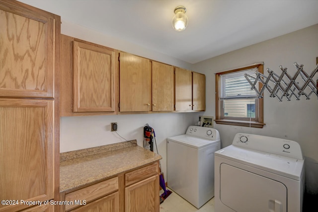 clothes washing area with cabinets and separate washer and dryer