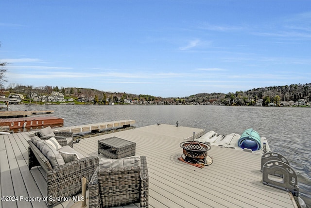 dock area featuring a fire pit and a deck with water view