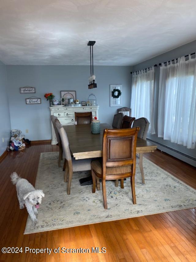 dining area with hardwood / wood-style floors and baseboard heating