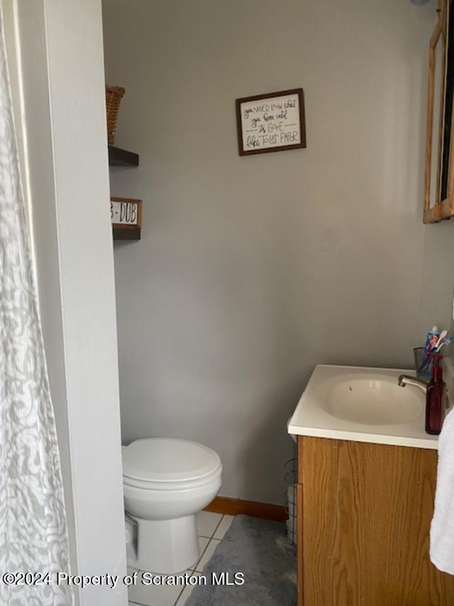 bathroom with tile patterned flooring, vanity, and toilet