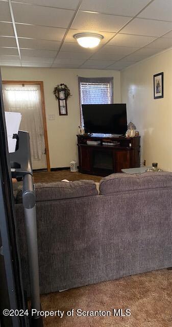 living room with carpet flooring and a drop ceiling