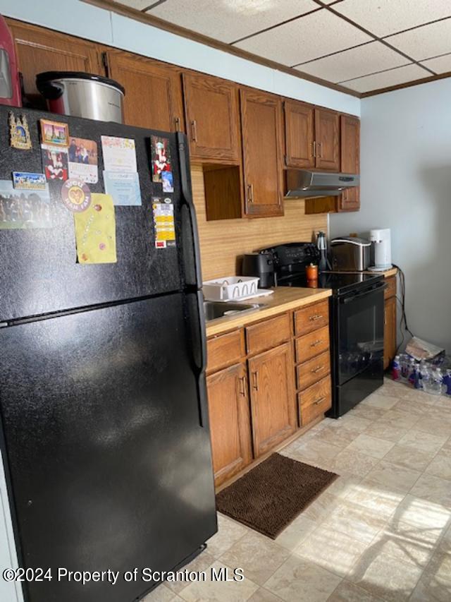 kitchen with crown molding and black appliances