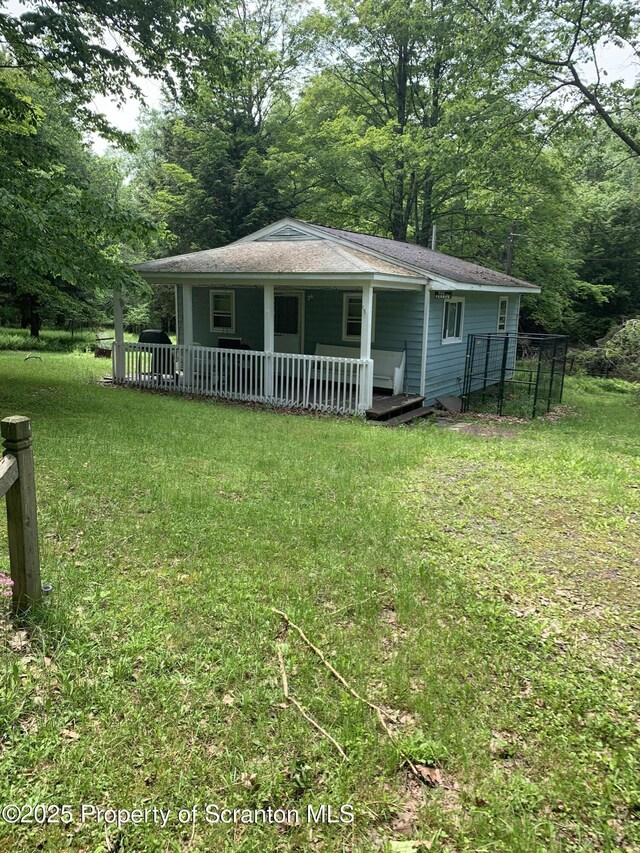 2385 Blewett Rd, Union Dale, PA 18470 - view of front facade with covered porch, a front lawn, and a shingled roof