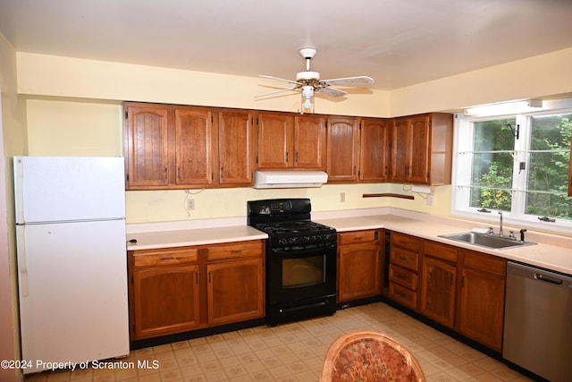 kitchen featuring black range with gas stovetop, sink, white refrigerator, dishwasher, and range hood