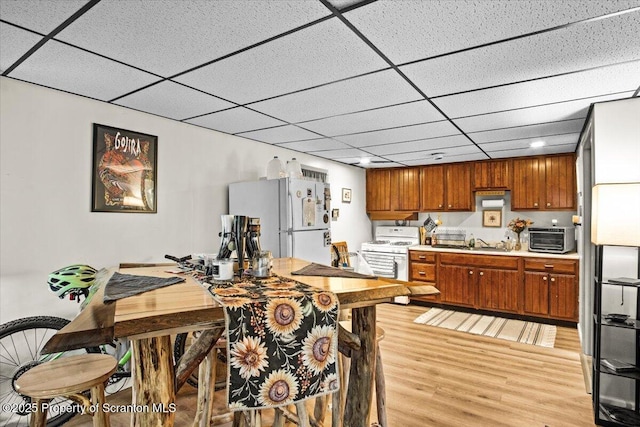 180 E Shore Dr, Dingmans Ferry, PA 18328 - kitchen with white appliances, light wood-style flooring, light countertops, a sink, and brown cabinets