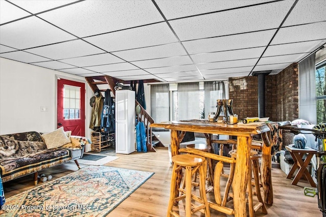 180 E Shore Dr, Dingmans Ferry, PA 18328 - dining space with a wood stove, a drop ceiling, a wealth of natural light, and wood finished floors
