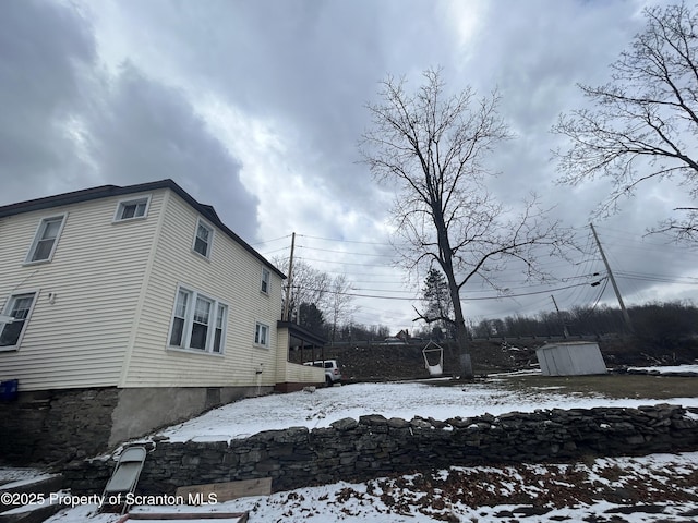 view of snowy exterior with a storage shed