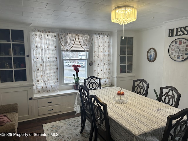 dining area featuring crown molding and dark wood-type flooring