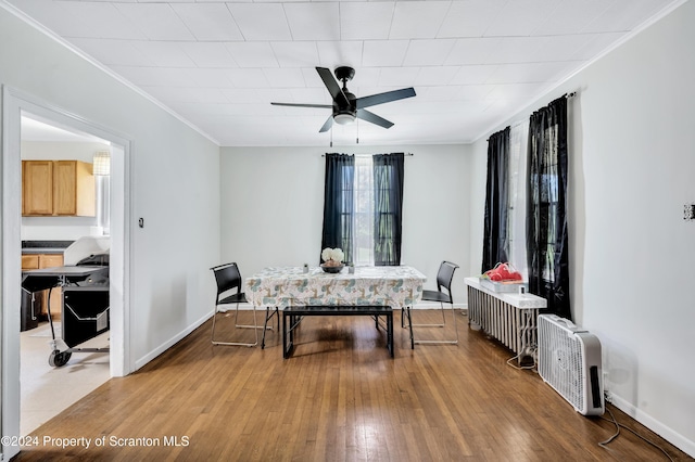 dining room featuring ceiling fan, wood-type flooring, ornamental molding, and radiator