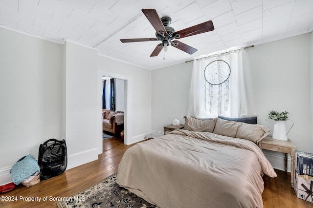 bedroom featuring wood-type flooring, ceiling fan, and ornamental molding