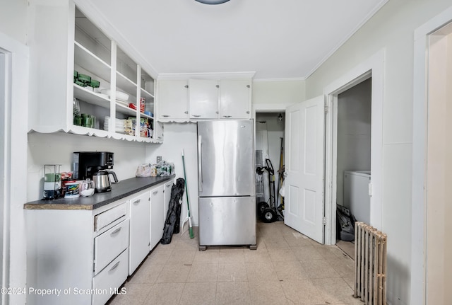 kitchen featuring stainless steel refrigerator, white cabinetry, radiator heating unit, and crown molding