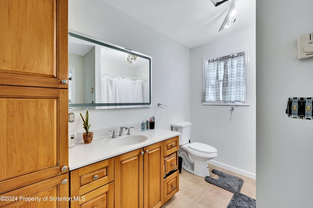 bathroom with tile patterned flooring, vanity, and toilet