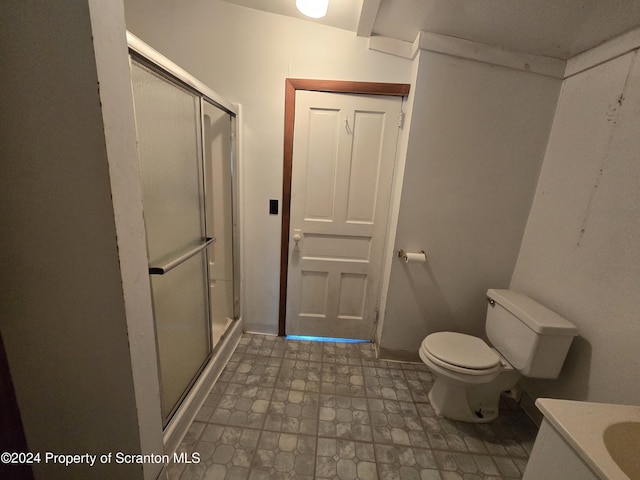 bathroom featuring vanity, toilet, and walk in shower