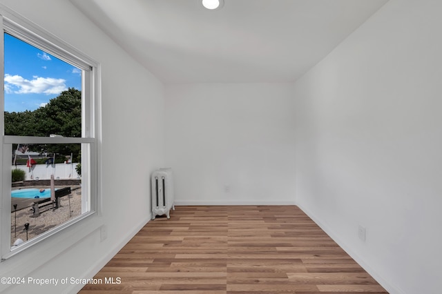 unfurnished room featuring radiator heating unit and light wood-type flooring