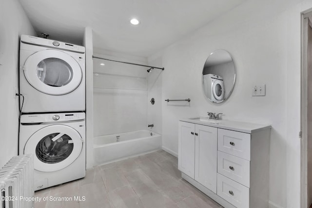 washroom featuring sink, stacked washer and clothes dryer, and radiator heating unit