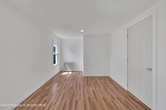 unfurnished room with light hardwood / wood-style flooring and radiator