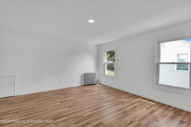 unfurnished room with light wood-type flooring and radiator