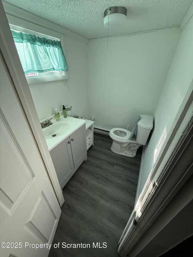 121 Throop St, Scranton, PA 18508 - bathroom featuring a textured ceiling, a baseboard radiator, toilet, wood finished floors, and vanity