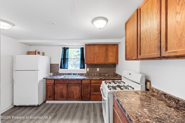 121 Throop St, Scranton, PA 18508 - kitchen with white appliances, light wood-style flooring, a sink, decorative backsplash, and brown cabinetry