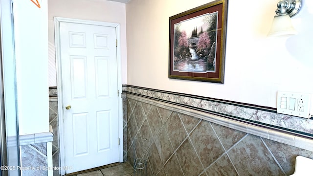 corridor with tile patterned flooring and tile walls