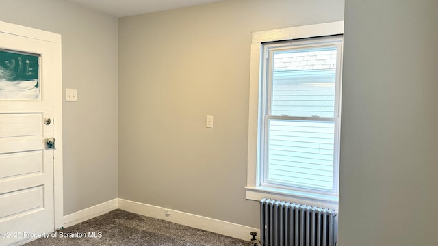 interior space featuring radiator and dark carpet