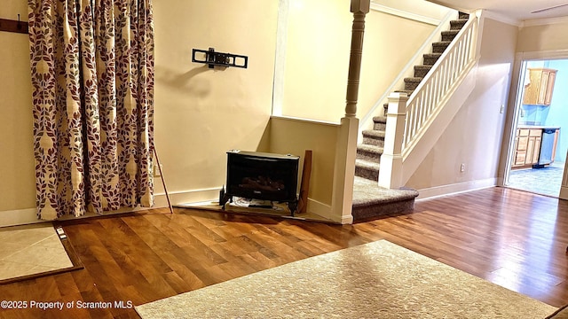 staircase featuring wood-type flooring and ornamental molding