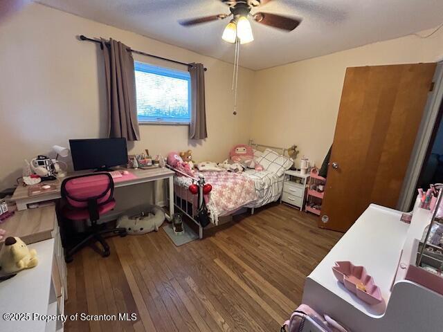 bedroom with ceiling fan and dark hardwood / wood-style floors