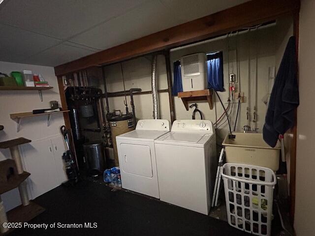 laundry room with sink, water heater, and washing machine and clothes dryer