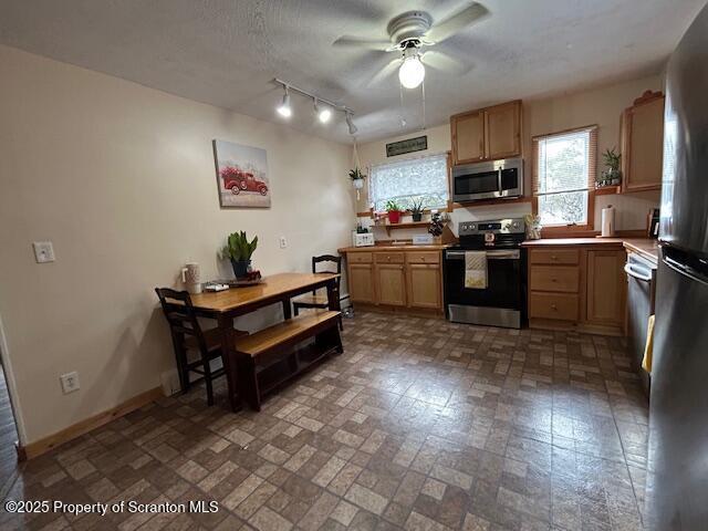 kitchen with ceiling fan, stainless steel appliances, and a textured ceiling